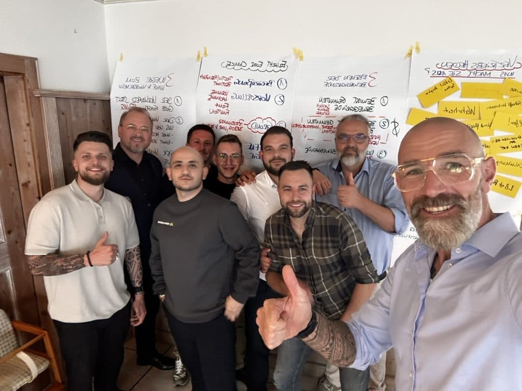 Tom Martens mit einer Trainingsgruppe vor Moderationswänden