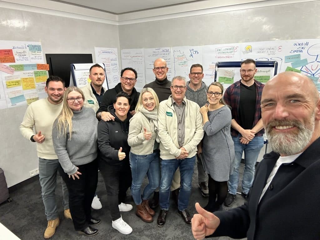 Gruppenfoto vor Flipcharts mit Arbeitsergebnissen