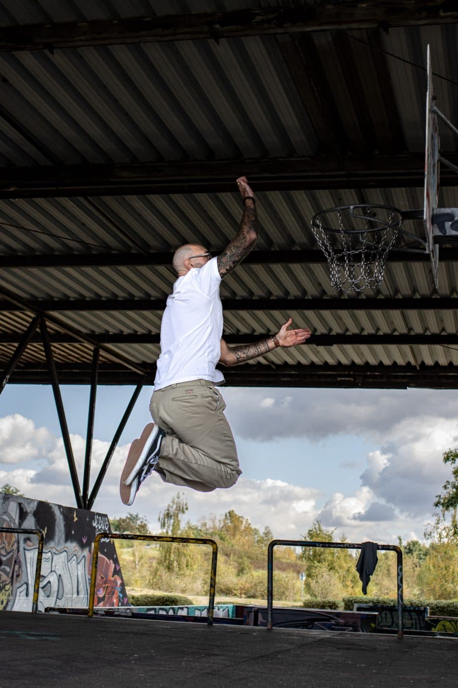 Tom Martens springt unter einem Hallendach Richtung Basketballkorb