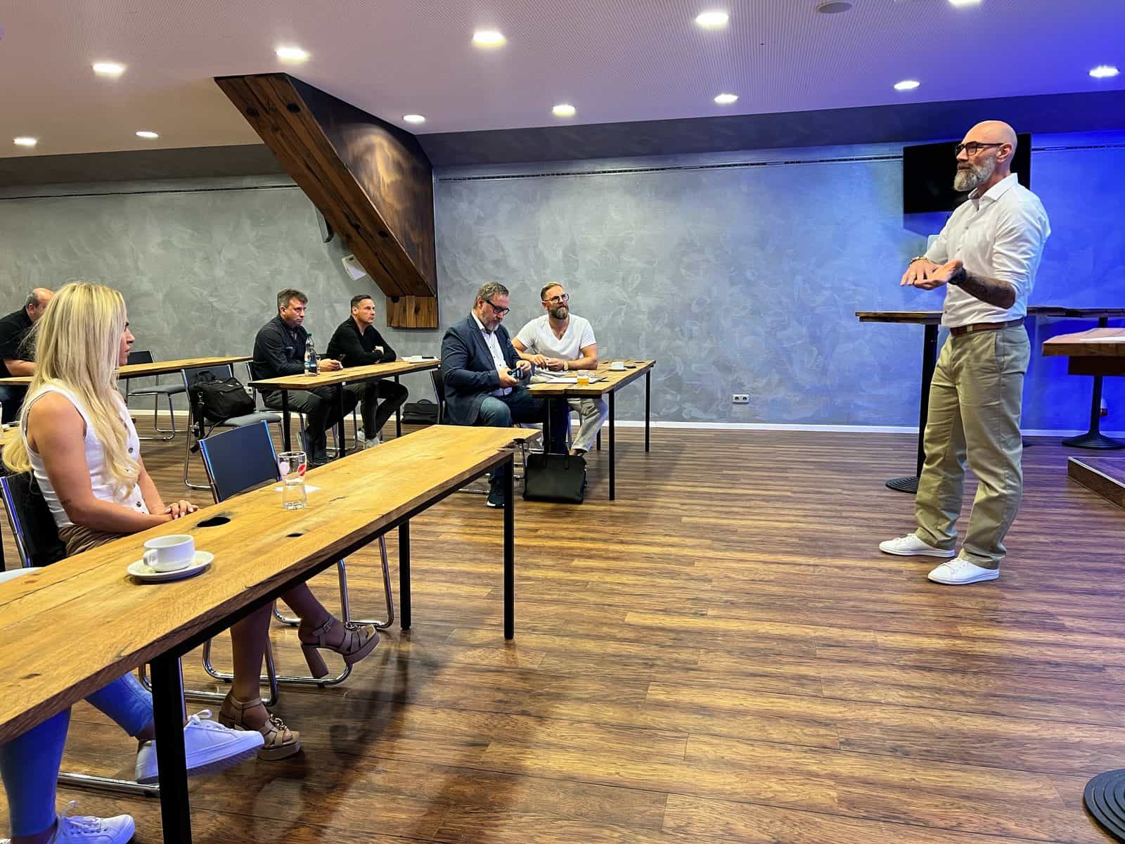 Tom Martens spricht frei vor einer Gruppe im Seminarraum